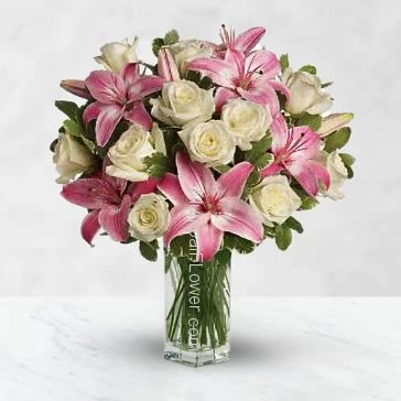 Glass vase with 5 stems of Asiatic pink lilies and 15 White roses nicely decorated with  greens 