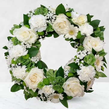 Beautiful and powerful, this lovely floral wreath conveys a message of love and affection. Its lovely flower blossoms will soothe,
and its outstanding beauty will convey the depth of your emotions.
<br>Arranged as:
Sympathy Flowers Round Wreath 20 White Roses, 20 White Gerberas and 10 White Carnation with fillers, greens and decorated with white ribbons.
