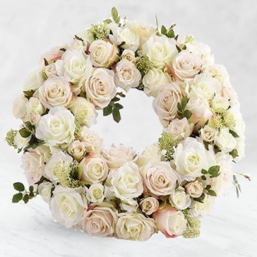 In their radiance, a hoop of subtle blooms thoughtfully displays your sentiment. Each flower is carefully selected to complement each other and the affection you are conveying.
<br>Arranged as: 
Round wreath of 45 White Roses and 25 Light Pink Roses nicely decorated with fillers, greens and Ribbons